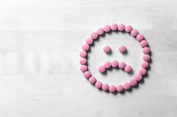 Pills forming a sad face which represents the negative effects of supplements