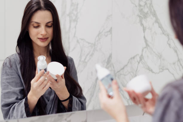 Woman reading labels of her skin care products