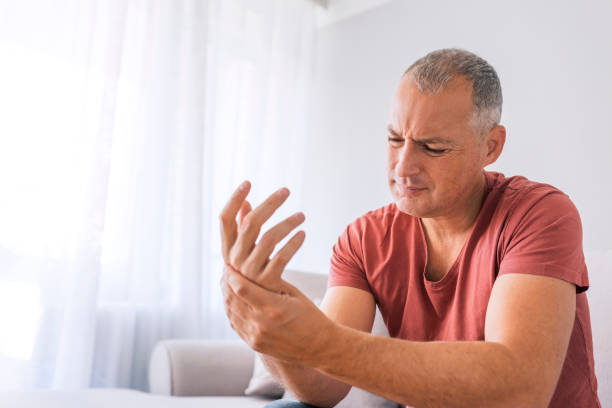 Man holding his hand due to joint pain