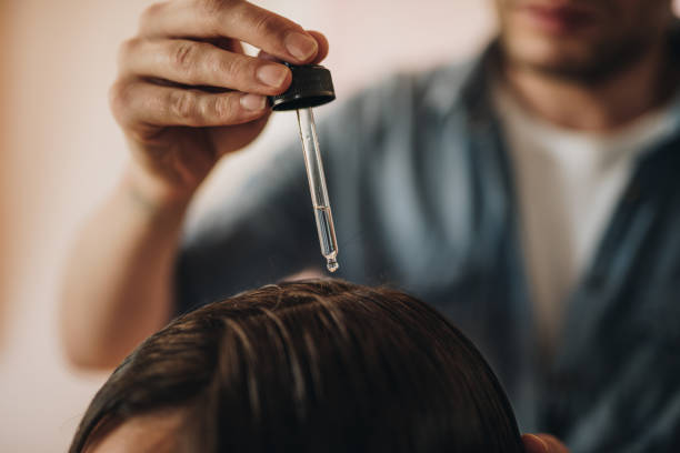 Specialist applying herb essentials for hair growth