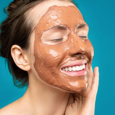 Woman applying mask on her skin as part of her skin care secret